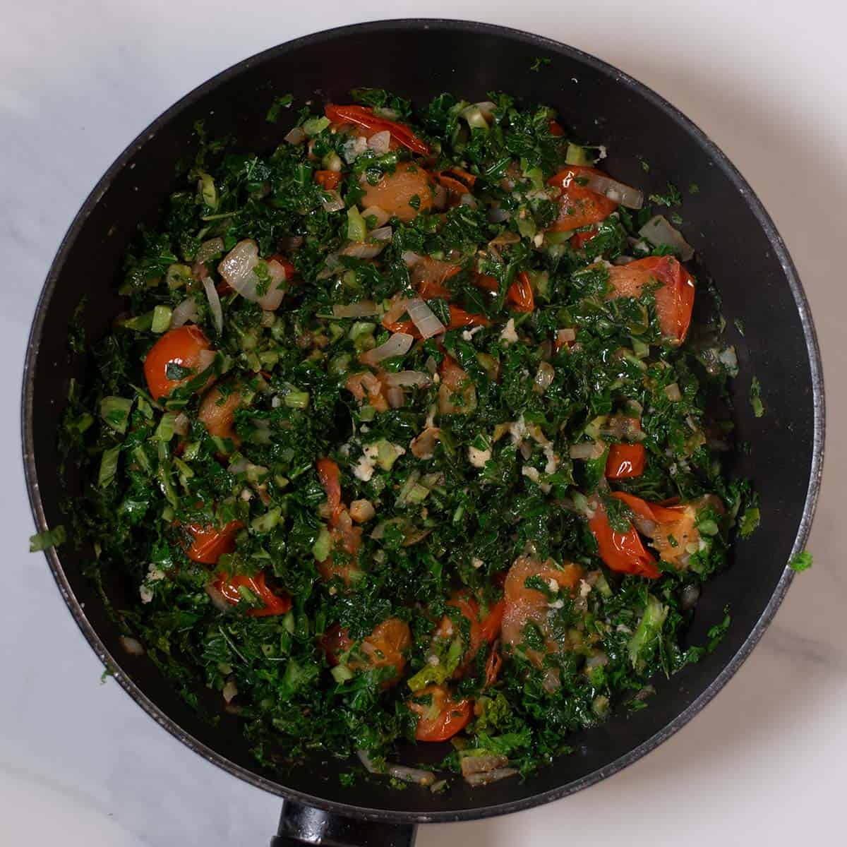Freshly cooked Tuscan kale and white beans in a skillet, vibrant and healthy.
